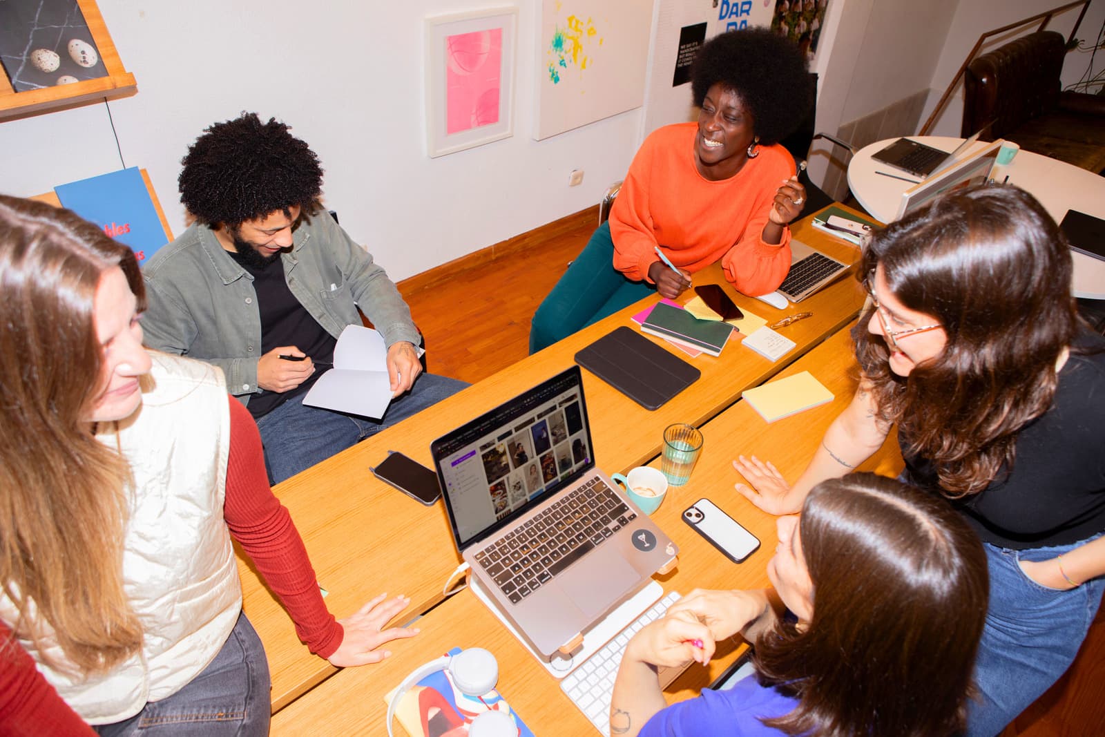 A diverse group of people collaborating around a table with laptops